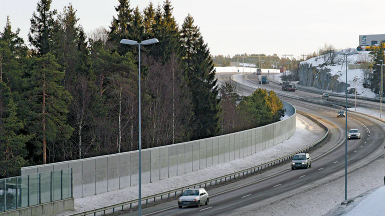 Acoustic panels forming acoustic barrier near road